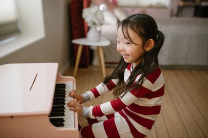 グランドピアノのそばで調律を行う調律師のシルエット